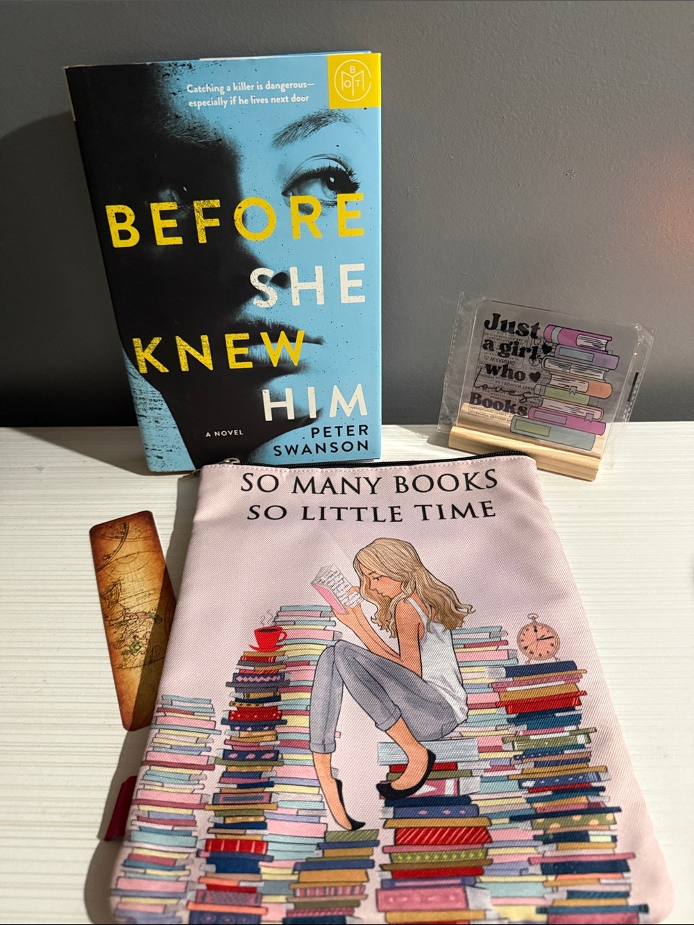 Before she knew him by Peter Swanson includes books sleeve, bookmark, and plaque